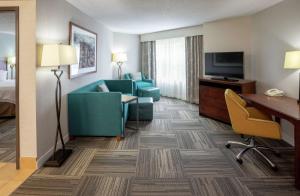 ein Hotelzimmer mit einem Sofa, einem Schreibtisch und einem TV in der Unterkunft Hampton Inn Duluth-Canal Park in Duluth