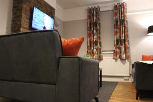 ein Wohnzimmer mit 2 Stühlen und einem TV in der Unterkunft St James 3 bedroom House in Tunbridge Wells in Royal Tunbridge Wells