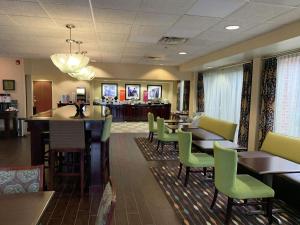 a restaurant with tables and chairs and a bar at Hampton Inn Danville in Danville