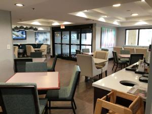 uma sala de espera com cadeiras e mesas e um restaurante em Hampton Inn El Dorado em El Dorado