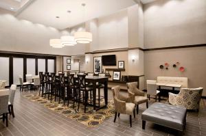 a restaurant with a bar with chairs and tables at Hampton Inn & Suites - Mansfield in Mansfield