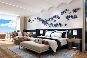 a bedroom with a large bed and a couch at The St Regis Al Mouj Muscat Resort in Muscat