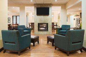 a waiting room with chairs and a fireplace at Hampton Inn White Plains/Tarrytown in Elmsford