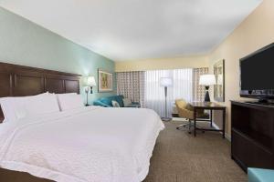 a hotel room with a large bed and a desk at Hampton Inn White Plains/Tarrytown in Elmsford +21 photos