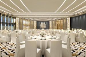 una sala de conferencias con mesa y sillas blancas en The St Regis Al Mouj Muscat Resort en Mascate