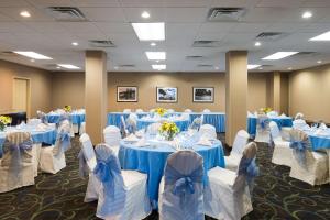 - une salle de banquet avec des tables bleues et des chaises blanches dans l'établissement Hampton Inn White Plains/Tarrytown, à Elmsford