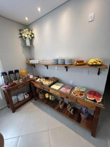 a kitchen with wooden shelves with food on them at Pousada Recanto Da Fé in Aparecida