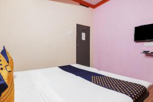 um quarto com uma cama e uma televisão na parede em OYO Hotel 74966 Shree Amardeep Hotel em Hyderabad