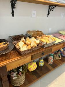 a shelf with baskets of bread and pastries on it at Pousada Recanto Da Fé in Aparecida