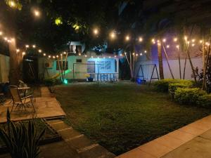 a backyard at night with lights and a house at La Casita in San Pedro Sula