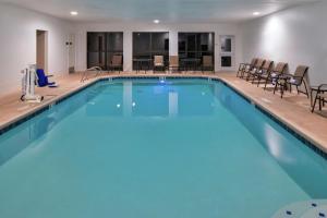 a pool with chairs and tables in a hotel at Hampton Inn Eugene in Eugene