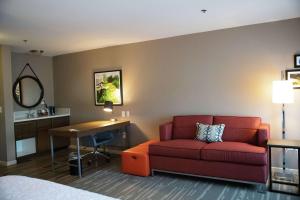 a hotel room with a couch and a desk at Hampton Inn & Suites Fresno in Fresno