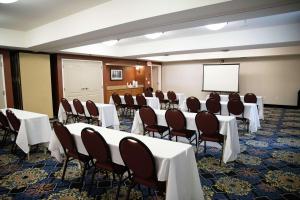 Hampton Inn & Suites Fresno في فريسنو: قاعة اجتماعات مع طاولات وكراسي وشاشة