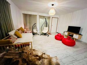 ミラマールにあるHermosa casa a estrenarのリビングルーム(赤いオブジェを床に配したリビングルーム、テレビ付)