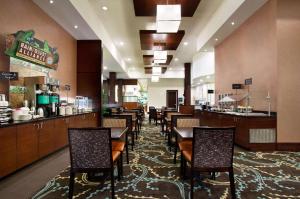a restaurant with tables and chairs and a bar at Embassy Suites by Hilton Fayetteville Fort Bragg in Fayetteville
