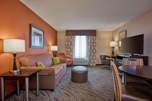 a living room with a couch and a tv in a hotel room at Hampton Inn Evansville Airport in Evansville