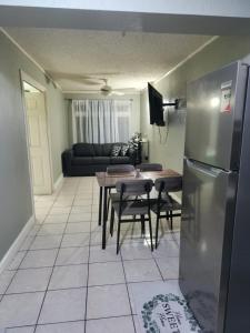 a kitchen with a table and a stainless steel refrigerator at JAMI PLACE in Kingston