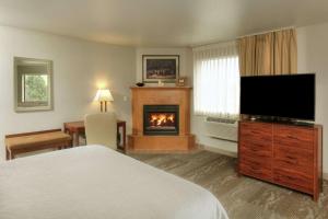 a hotel room with a bed and a fireplace at Hampton Inn Kalispell in Kalispell