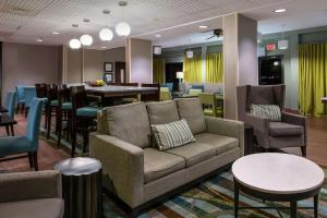 a living room with a couch and tables and chairs at Hampton Inn Florence Midtown near University of North Alabama in Florence