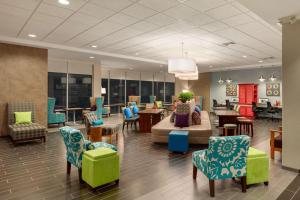 a lobby with a waiting room with chairs and a couch at Home2Suites by Hilton Florence in Florence