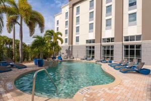 a swimming pool in front of a building at Hampton Inn & Suites Fort Myers-Colonial Boulevard in Fort Myers