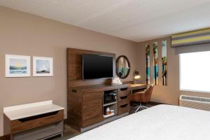 a bedroom with a desk with a television and a bed at Hampton Inn & Suites Fort Myers-Colonial Boulevard in Fort Myers