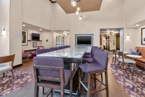 a lobby with a large bar with purple chairs at Hampton Inn and Suites Flint/Grand Blanc in Flint