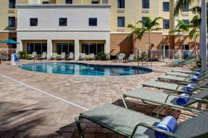 a swimming pool with lounge chairs and a building at Hampton Inn and Suites Coconut Creek in West Dixie Bend