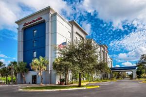 タマラックにあるHampton Inn & Suites Ft. Lauderdale/West-Sawgrass/Tamarac, FLのアメリカ旗を掲げたホテルの建物