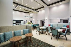 una sala de espera con sofá, mesas y sillas en Hampton Inn & Suites Ft. Lauderdale/West-Sawgrass/Tamarac, FL en Tamarac