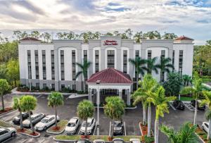 an aerial view of a hotel with cars parked in a parking lot at Hampton Inn & Suites Fort Myers Estero in Estero