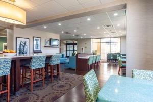 a restaurant with a bar with blue chairs at Hampton Inn Front Royal in Front Royal