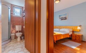 ein Schlafzimmer mit einem Bett und ein Badezimmer mit einem WC in der Unterkunft Apartment LOLA in Medulin