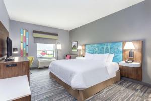 een hotelkamer met een bed en een televisie bij Hampton Inn Auburn in Auburn
