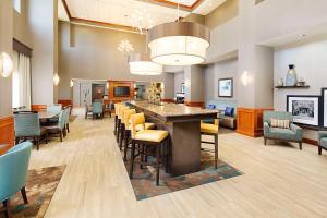 a large room with a bar with chairs and tables at Hampton Inn & Suites - Mansfield in Mansfield