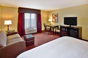 ein Hotelzimmer mit einem Bett und einem Flachbild-TV in der Unterkunft Hampton Inn Ft Wayne in Fort Wayne