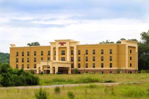 ein großes gelbes Gebäude in der Mitte eines Feldes in der Unterkunft Hampton Inn Fayetteville in Fayetteville