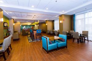 un restaurante con mesas y sillas azules y un comedor en Hampton Inn Fayetteville, en Fayetteville