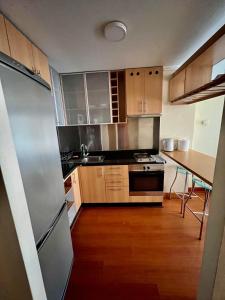 サンティアゴにあるDepartamento con ubicacion perfecta en las condesのキッチン(ステンレス製の冷蔵庫、テーブル付)