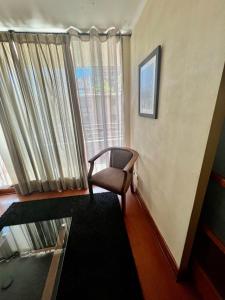 サンティアゴにあるDepartamento con ubicacion perfecta en las condesのリビングルーム(椅子、窓付)