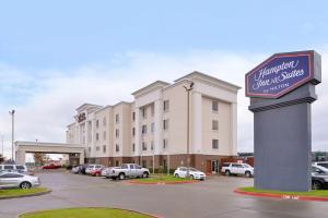 Hampton Inn & Suites Greenville في غرينفيل: مبنى كبير مع وجود لافته في موقف السيارات