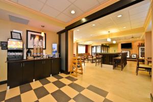 a lobby with a bar and a restaurant with tables at Hampton Inn - Greenville in Greenville