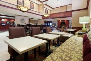 a restaurant with tables and chairs and a bar at Hampton Inn & Suites Grove City in Grove City