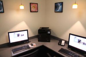 a desk with two computer monitors and a printer at Hampton Inn Greeneville in Greeneville