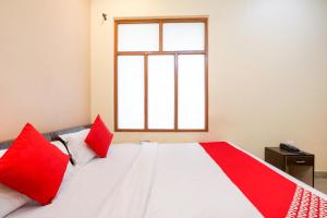 a bedroom with a large bed with red pillows at OYO Trimurti Palace Near Gomti Riverfront Park in Vibhuti Khand