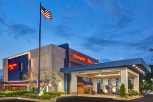 una bandera americana ondeando frente a un hotel en Hampton Inn Greenwood, en Greenwood