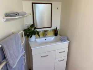 un baño con lavabo y espejo en Oneroa Chalet, en Oneroa