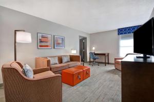 a living room with a couch and a tv at Hampton Inn Greenwood in Greenwood