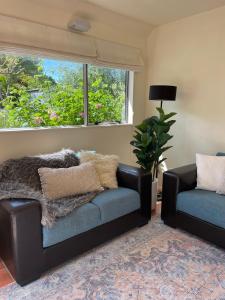 a living room with a couch and a window at Oneroa Chalet in Oneroa