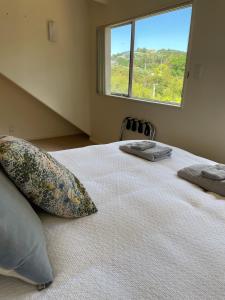 a bedroom with a large bed with a large window at Oneroa Chalet in Oneroa